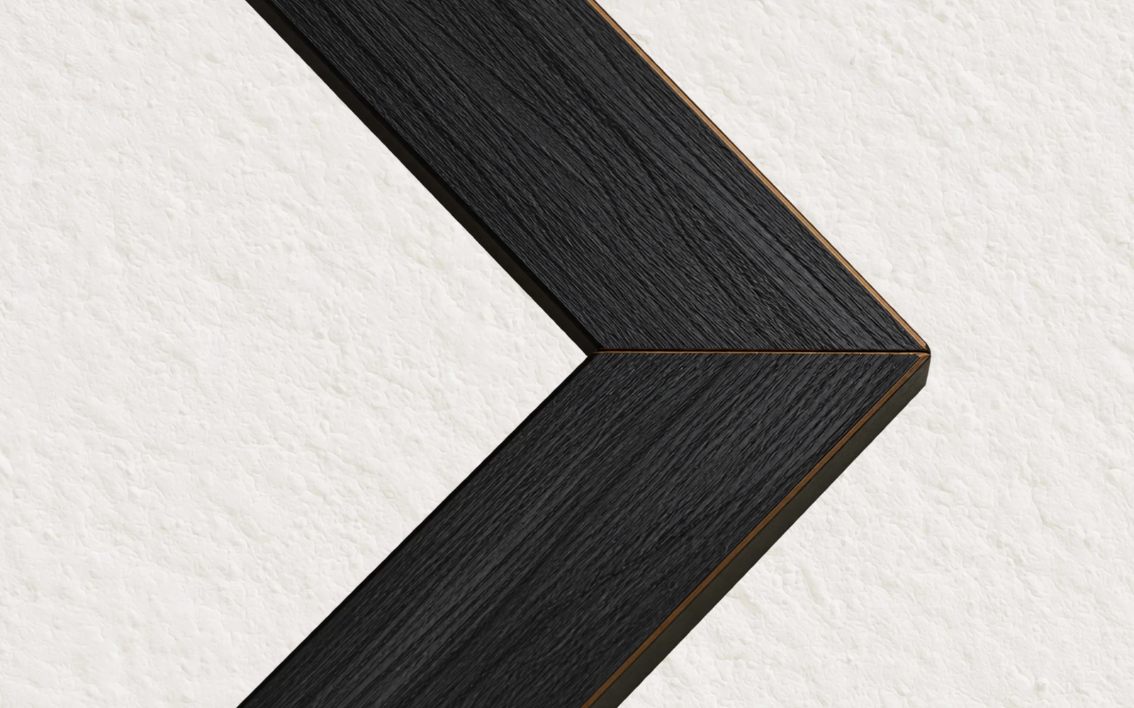 The mitred corner of a black stained wood frame