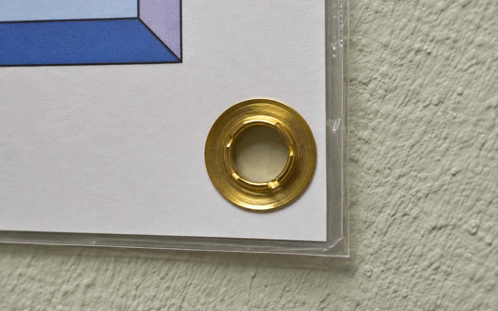 Close-up of a brass grommet set into the edge of a laminated map
