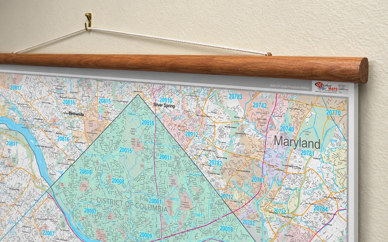 A mounted map hanging from a wooden rail and cord against an office wall