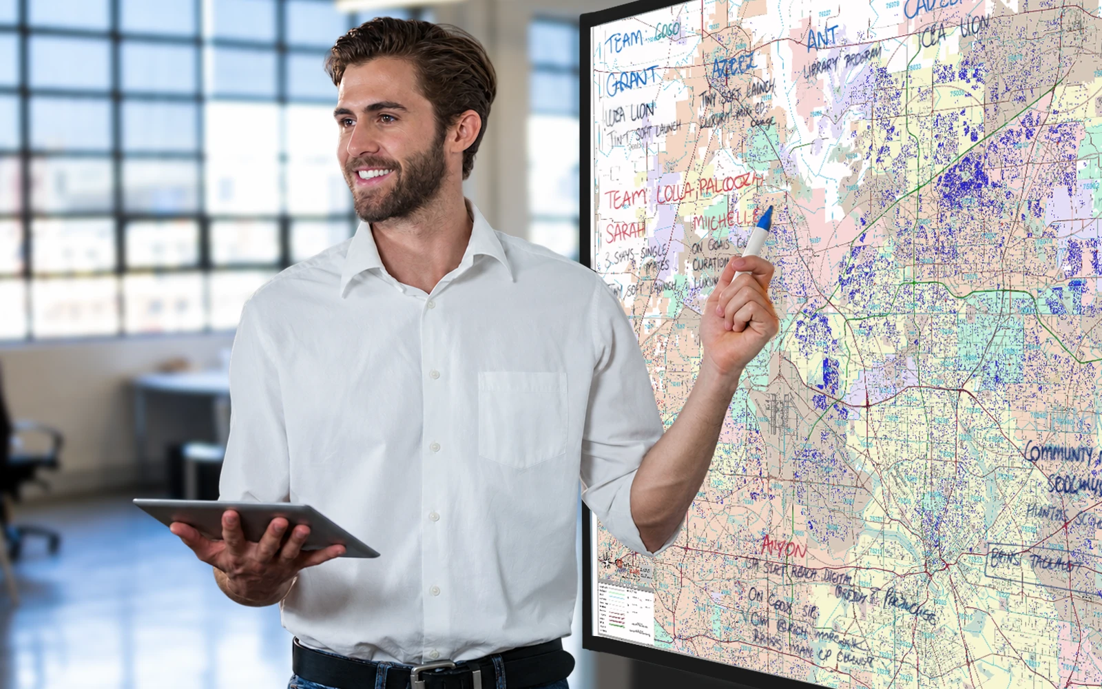 A man presenting at a mounted wall map in an office