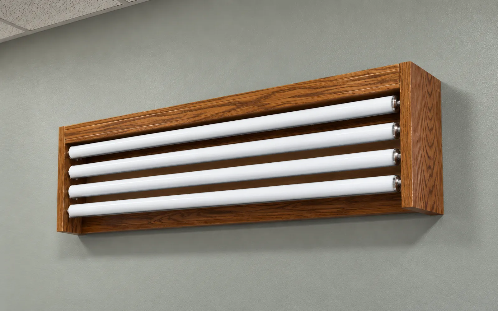 A wood valance box on a wall holding four white spring rollers