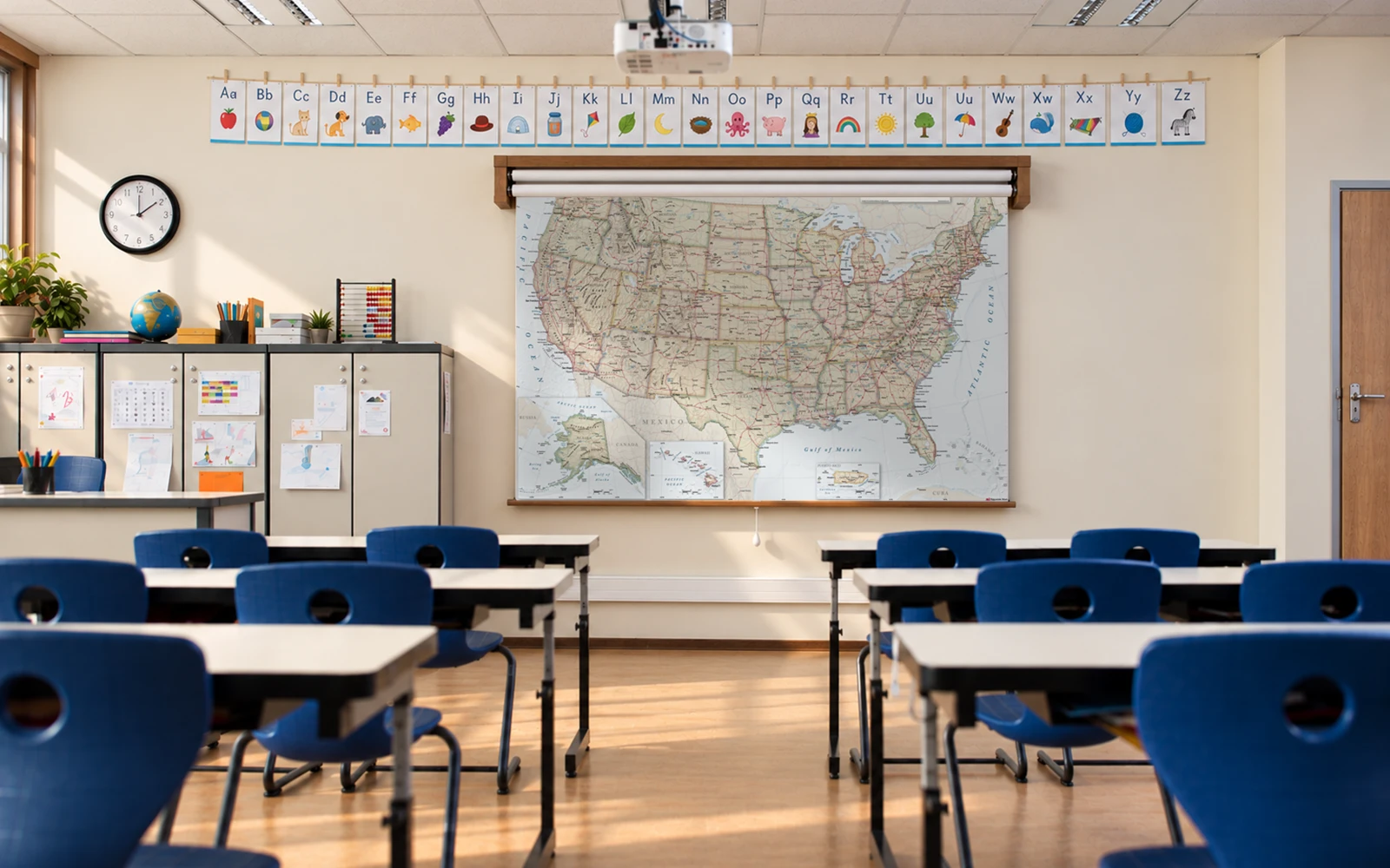 A classroom with a pull-down United States map above the whiteboard